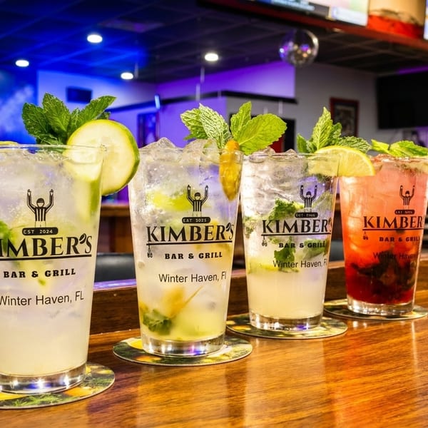 Four mojitos, two lime and two berry, on a wooden bar at Kimber's Bar & Grill.